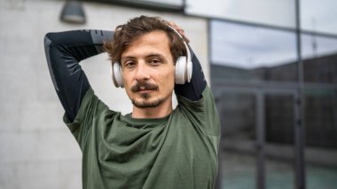 One man modern caucasian male stretch outdoor before training wear green shirt and mustaches and beard young adult recreational activity