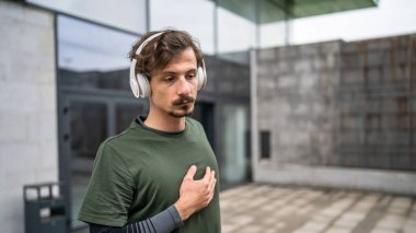 One man modern caucasian male stretch outdoor before training wear green shirt and mustaches and beard young adult recreational activity