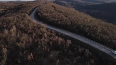 Aerial view on the road with cars automobile passing driving travel concept in autumn or winter day trough the trees on asphalt on Tresibaba Serbia