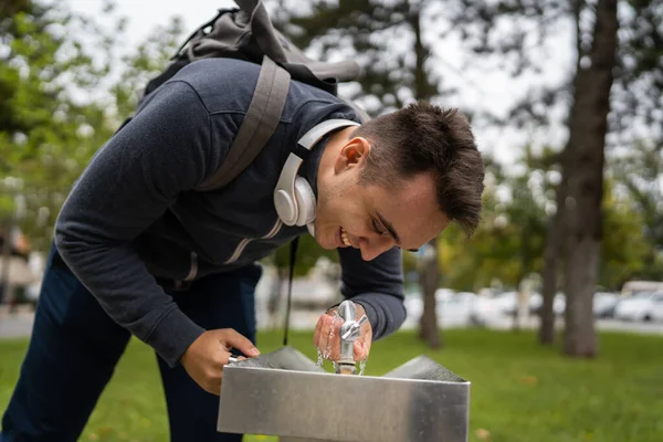 stock image One man caucasian male drink water at public fountain in the city town