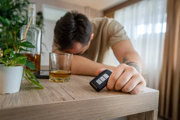 1人の男が家に座って酒を飲んで酒を飲んで酒を飲んで酒を飲んで酒を飲んで中毒と男うつ病のコンセプトドリンクとドライブコピースペースホールド車のキー — ストック写真