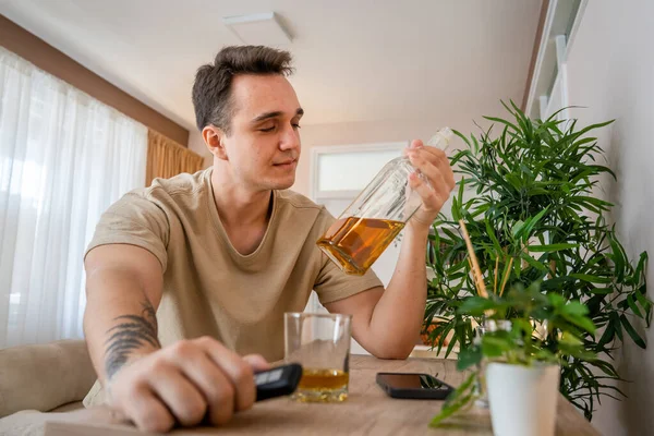 Bir Adam Evde Bir Şişe Likörle Oturup Viski Içiyor Alkollü — Stok fotoğraf