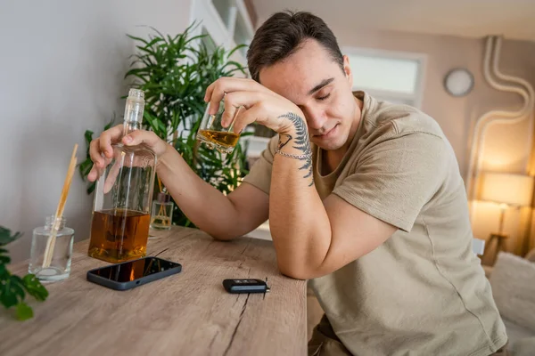 1人の男が酒を飲んで酒を飲んで家に座っていますウイスキー飲酒アルコール乱用中毒と男うつ病の概念コピースペース — ストック写真