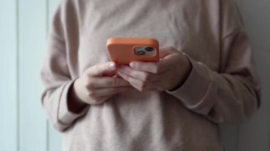 Bilinmeyen Kafkasyalı kadının orta kesiminde akıllı cep telefonu kullanarak mesaj gönderme ya da internet sosyal ağlarına göz atma