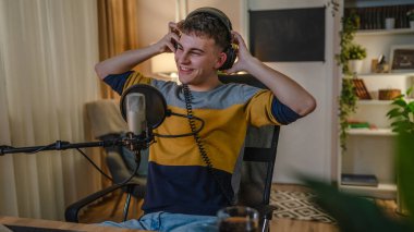 One man caucasian male blogger or vlogger gesticulating while streaming video podcast in broadcasting studio use microphone and headphones famous influencer shooting video for channel podcast