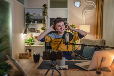 One man caucasian male blogger or vlogger gesticulating while streaming video podcast in broadcasting studio use microphone and headphones famous influencer shooting video for channel podcast