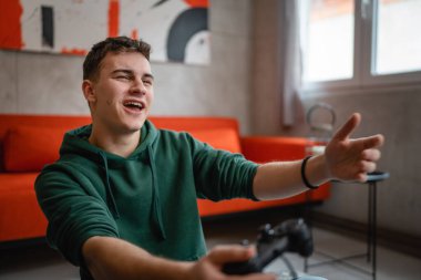 Beyaz tenli bir genç erkek, evinde video oyunu oynuyor ve kaybediyor.
