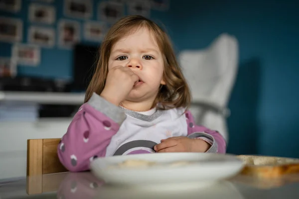 ある女の子は白人の幼児女性の子供が家のテーブルで食べます — ストック写真