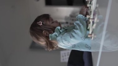 Bir beyaz çocuk, iki yaşında evde tek başına oyun oynuyor. Çocukluk gelişimi kavramının içine tahta parçaları koyuyor.