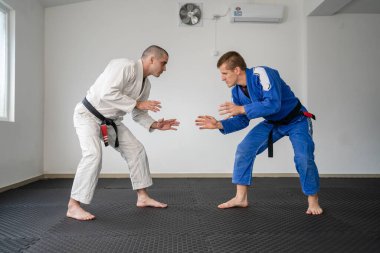 Brezilya jiu jitsu bjj eğitimi ya da iki sporcuyu serbest bırakmak tatami minderlerinin üzerinde diyet dövüş sanatları tekniği kimono gi siyah kuşak eğitmeni tekniği uygula.