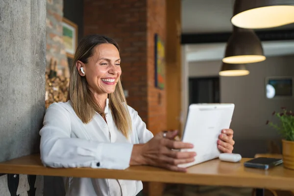 一人の女性大人成熟した白人女性の仕事は自宅や職場のレストランでテーブルの屋内に立っている間 デジタルタブレットを使用して白いシャツコピースペース幸せな笑顔を身に着けています — ストック写真