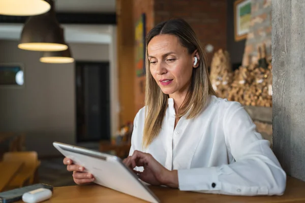 1人の女性大人成熟した白人女性起業家マネージャーは 自宅や職場でテーブルの屋内に立っている間 デジタルタブレットを使用して作業白いシャツコピースペースを身に着けている — ストック写真