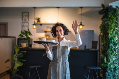 Kafe ya da lokantada çalışan olgun bir kadın garson kahve tepsisi taşıyor. İş yerindeki bayan girişimci. Gerçek insanlar uzay küçük işletme konseptini kopyalıyor.