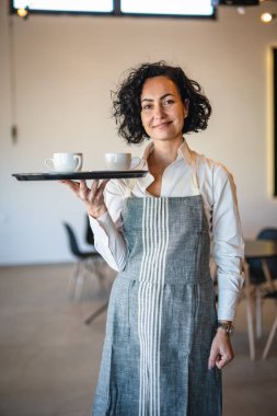 Kafe ya da lokantada çalışan olgun bir kadın garson kahve tepsisi taşıyor. İş yerindeki bayan girişimci. Gerçek insanlar uzay küçük işletme konseptini kopyalıyor.