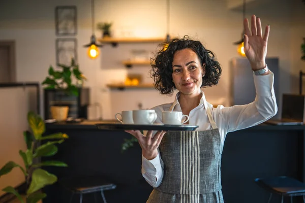 カフェやレストランで成熟した女性のカフェアジアのウェイトレスは 仕事でコーヒー女性起業家とトレイを運ぶ実際の人々はスペースをコピー小さなビジネスコンセプト — ストック写真