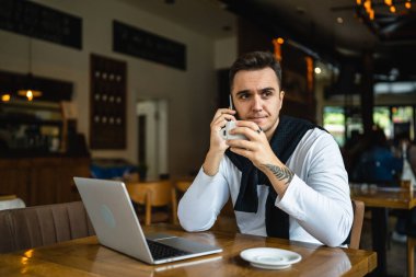 Kafe ya da restoranda masada oturan bir adam telefon görüşmesi yapmak için gündelik kıyafet giyer. Elinde bir fincan kahve tutarken gerçek insanlar uzay çözme problemini kopyalarlar.