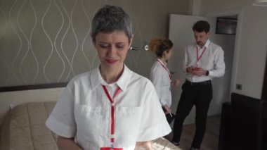 Kadın girişimci takım lideri otel odasında meslektaşlarının önünde duruyor. İş konferansına hazırlanın. Gerçek girişimcilerle tanışın. 