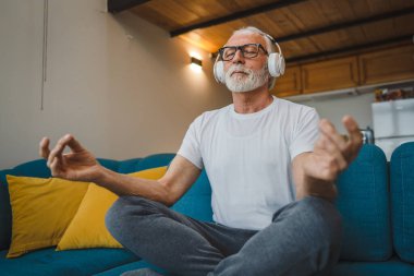 Üst düzey Kafkas erkek gözleri, kulaklıklarla evde otururken yoga ya da meditasyon için kapalı. Gerçek insanların iç huzuru ve denge konsepti.