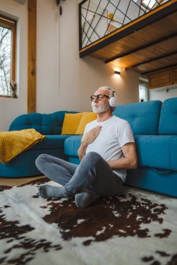 Üst düzey Kafkas erkek gözleri, kulaklıklarla evde otururken yoga ya da meditasyon için kapalı. Gerçek insanların iç huzuru ve denge konsepti.