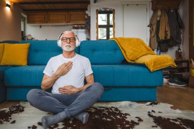Üst düzey Kafkas erkek gözleri, kulaklıklarla evde otururken yoga ya da meditasyon için kapalı. Gerçek insanların iç huzuru ve denge konsepti.