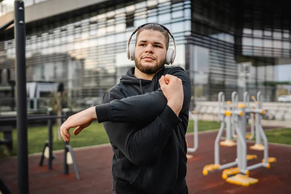 man stretching before or after training in the open gym outdoor in day in the city real people healthy lifestyle concept leisure amateur exercise