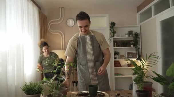 家庭植物の世話を一緒に一緒に花を植える夫婦の白人男性と女性の妻家庭菜園のコンセプトコピースペース — ストック動画