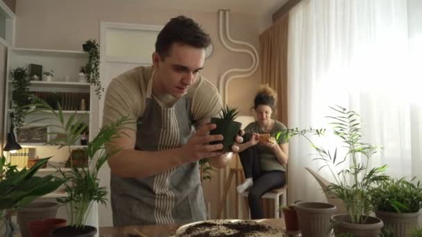 家庭植物の世話を一緒に一緒に花を植える夫婦の白人男性と女性の妻家庭菜園のコンセプトコピースペース — ストック動画