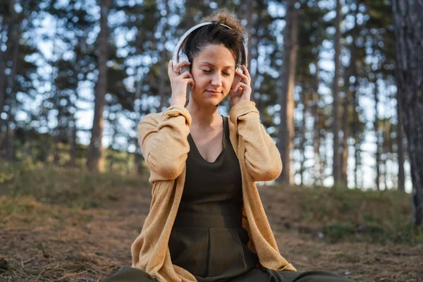 Yetişkin Bir Kadın Parkta Ormanda Tek Başına Oturmuş Elinde Kulaklık — Stok fotoğraf