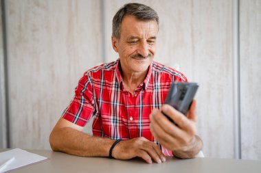 Üst düzey girişimci, aktif, beyaz bir erkek, masa başında çalışırken telefonla konuşuyor ve küçük işletmelerde çalışıyor. Gerçek insanlar uzay kopyaları yapıyor.