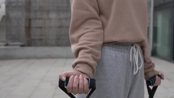 코카서스 선수가 일상적 운동에서 반창고 튜브를 사용하여 밖에서 훈련하는 사람들의 — 비디오