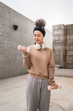 Yetişkin Kafkasyalı kadın, günlük antrenmanında halterli ağırlık kullanan kadın sporcu. Gerçek insan sağlığı ve zindelik konsepti uzay fotokopisi.