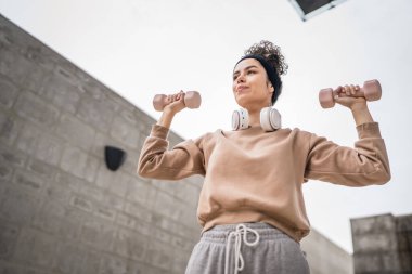 Yetişkin Kafkasyalı kadın, günlük antrenmanında halterli ağırlık kullanan kadın sporcu. Gerçek insan sağlığı ve zindelik konsepti uzay fotokopisi.
