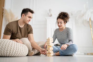 Kadın ve erkek mutlu Kafkasyalı karı koca ya da arkadaşlar evde Jenga masası oyunu oynuyorlar ciddi bir eğlence birlikte vakit geçiriyorlar aile zamanı, gerçek insanları kopyalıyorlar.