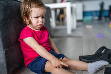 Bir kız evdeki kanepede oturuyor. Kötü bir duygu.