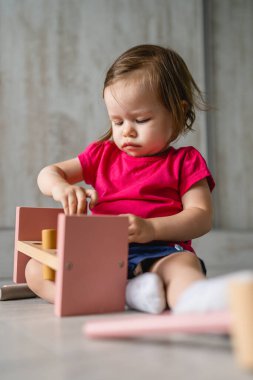 one child small caucasian girl little toddler playing with educational toys at home childhood and growing up early development concept copy space front view