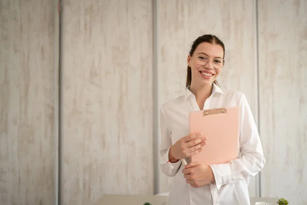 stock image One woman caucasian female businesswoman entrepreneur manager or secretary standing in her office front view copy space happy smile confident with cup of coffee using mobile phone to make a call