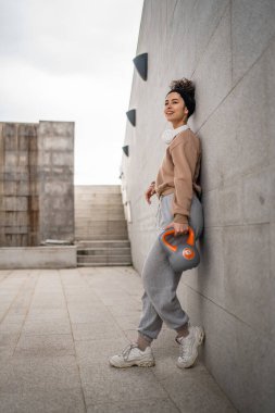 Kafkasyalı genç bir bayan sporcu gün içinde dışarıda Rus çanı Girya Kettlebell ağırlık egzersizi ile antrenman yapıyor.