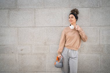 Kafkasyalı genç bir bayan sporcu gün içinde dışarıda Rus çanı Girya Kettlebell ağırlık egzersizi ile antrenman yapıyor.