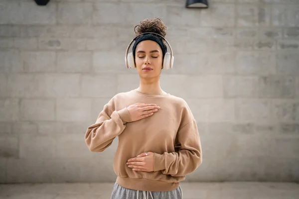 オンラインガイド付き瞑想のためのヘッドフォンを使用して1人の女性大人の白人女性目を閉じてマインドフルネス症状を練習屋外の現実の人々セルフケアコンセプトコピースペース — ストック写真