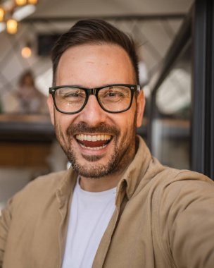 Bir modern yetişkin beyaz erkek portresi sakallı ve gözlüklü mutlu ev portresi kendinden emin UGC kullanıcısı tarafından oluşturulan içerik.