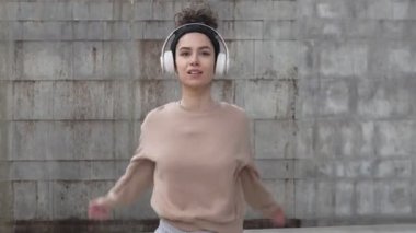 Kafkasyalı genç bir bayan sporcu gün içinde dışarıda durup esneme egzersizi yapıyor ve gerçek bir insanı ısıtıyor.