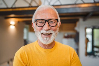 Gündüz evinde sakallı bir erkek büyükbabanın modern beyaz portresi sarı süveter giyip kendine güvenen bir fotokopi odası portresi giyiyor.