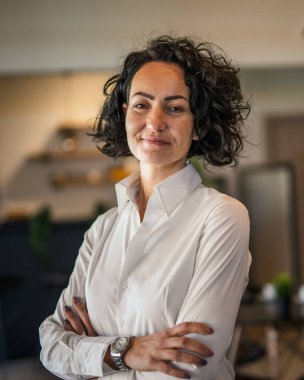 Yetişkin bir kadın Kafkas kadın iş kadını iş yerinde ya da evde duruyor gerçek insanlar yer kopyalıyor beyaz gömlek kıvırcık saçlar giyiyor