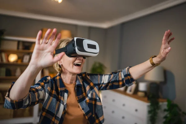 一位成熟的老年高加索女性在家里享受虚拟现实Vr耳机 — 图库照片