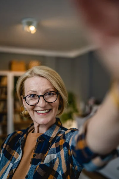 一个成熟的金发碧眼女人的画像 带着眼镜在家里开心地笑着看着相机自信地穿上衬衫复制空间 — 图库照片