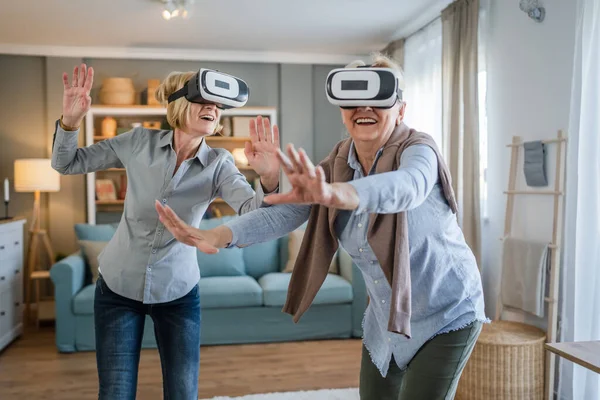 两个成熟的老年高加索女性老年母亲和女儿在家里享受虚拟现实Vr耳机活跃的老年概念复制空间 — 图库照片