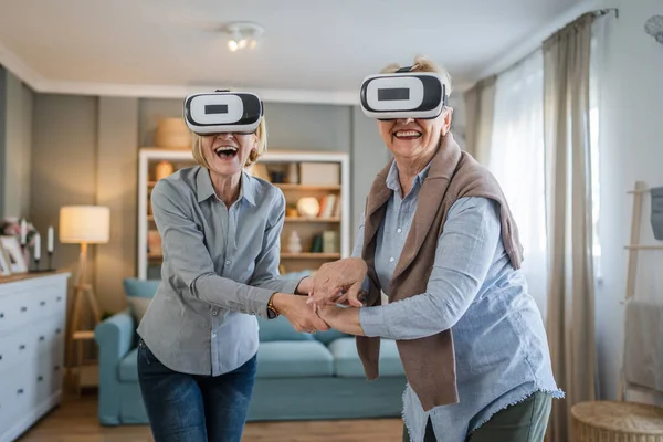 两个成熟的老年高加索女性老年母亲和女儿在家里享受虚拟现实Vr耳机活跃的老年概念复制空间 — 图库照片