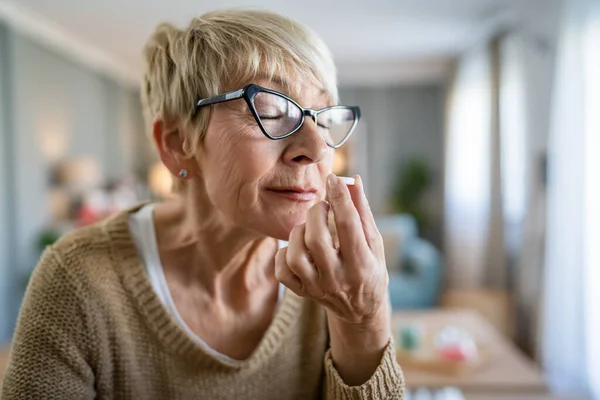 高齢の白人女性の1人が薬を服用するか または自宅でビタミンの効果的な錠剤の匂いを補う実際の人々の医療概念 — ストック写真
