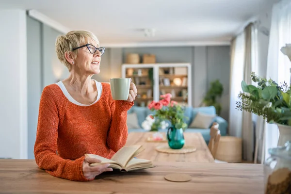 一人の女性成熟しましたシニアCaucasian女性Pensioner現代祖母とともに短い毛読み本でホームウェア眼鏡本物の人コピースペース — ストック写真