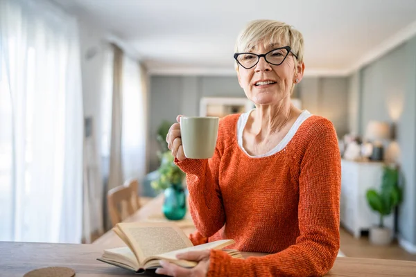一人の女性成熟しましたシニアCaucasian女性Pensioner現代祖母とともに短い毛読み本でホームウェア眼鏡本物の人コピースペース — ストック写真
